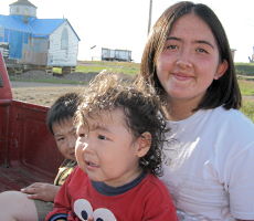 An Inuit young person with 2 children